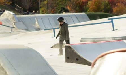 a man standing on a skateboard ramp at a skate park