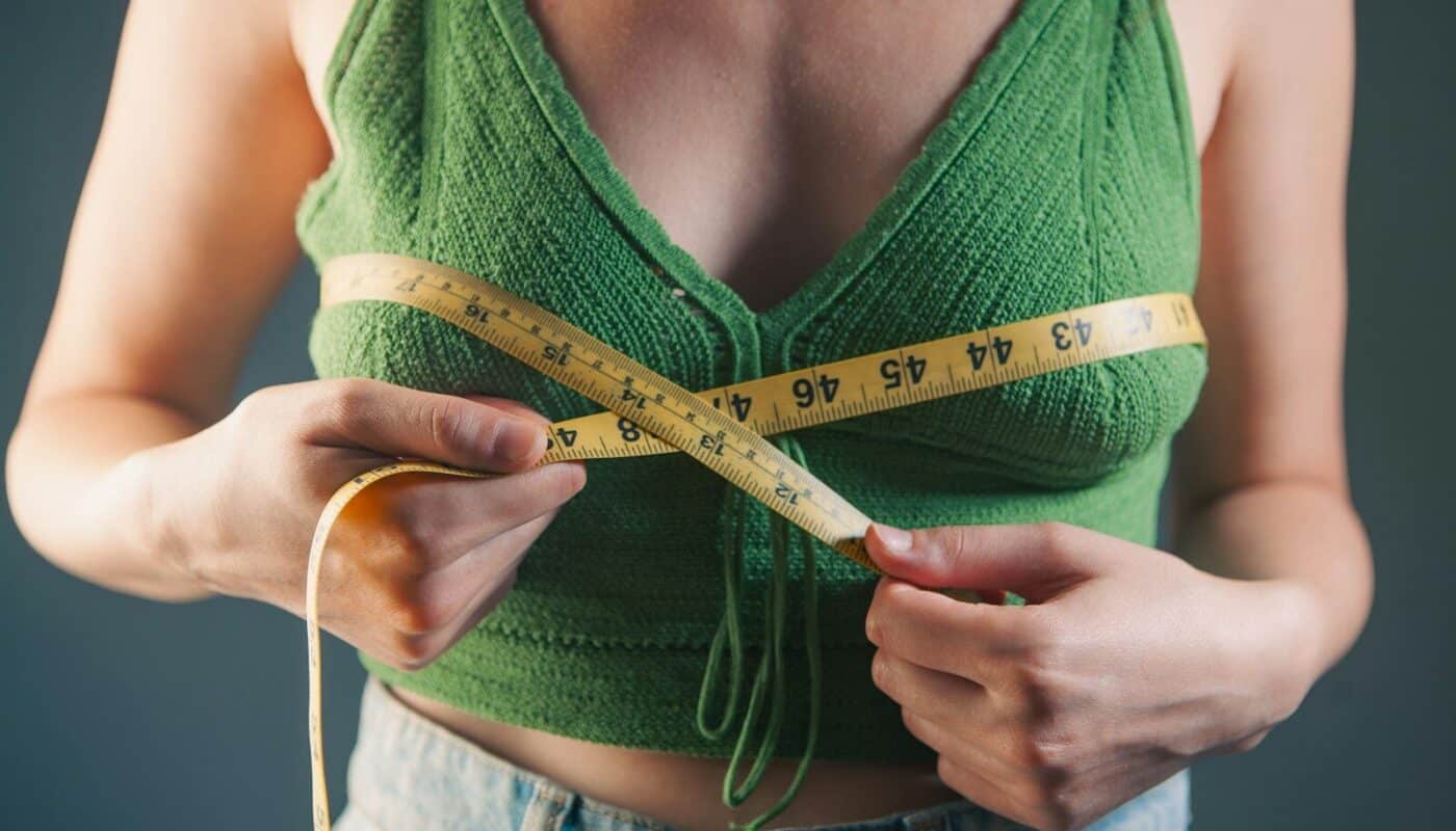Woman measuring her bust with a tape measure