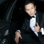 man in black blazer sits inside the car