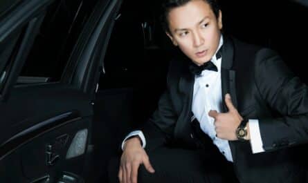 man in black blazer sits inside the car