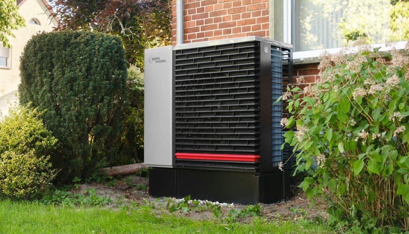 Outdoor heat pump unit next to a brick building