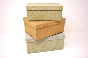 Trois boîtes de rangement en carton et tissu sur fond blanc