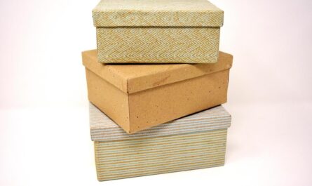 Trois boîtes de rangement en carton et tissu sur fond blanc