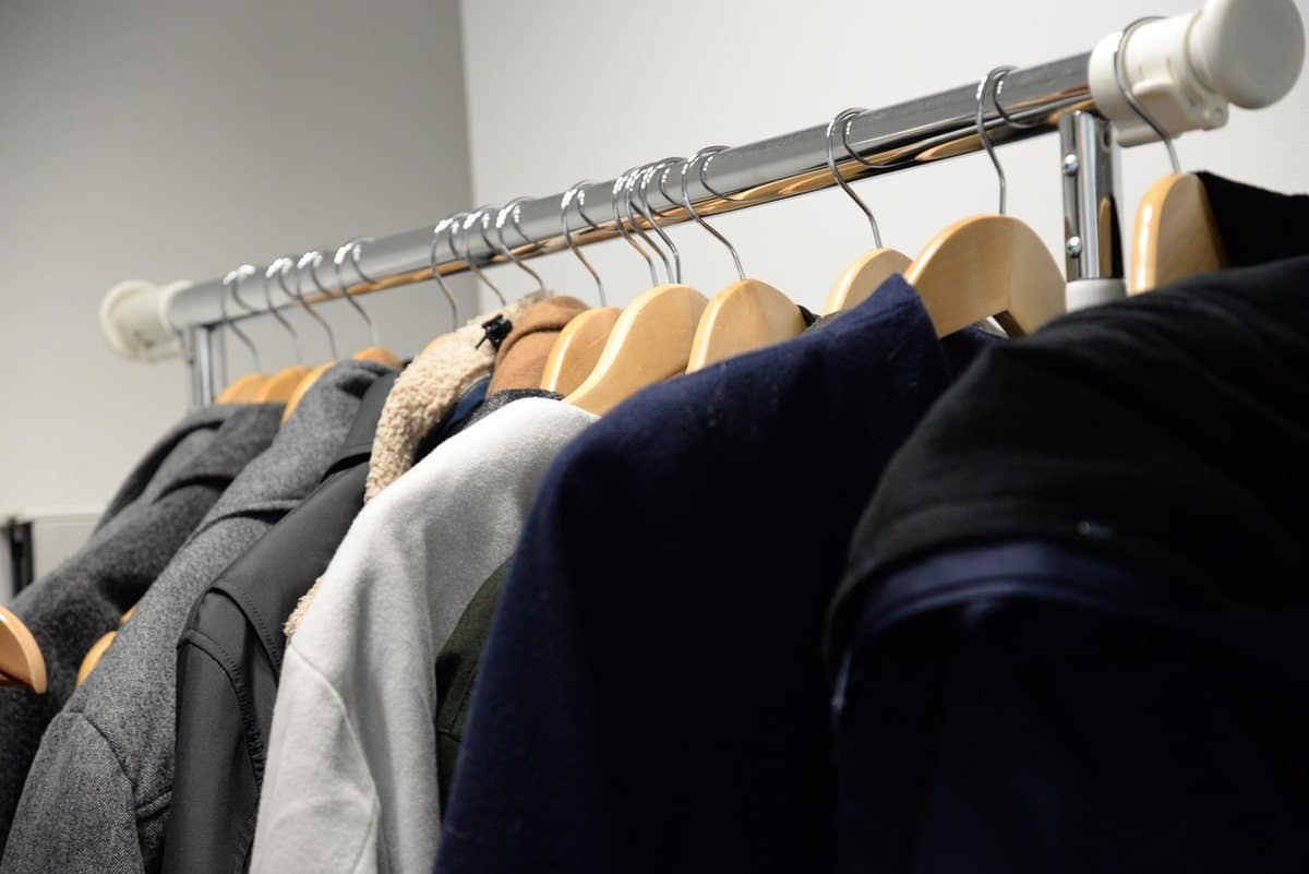 Vêtements accrochés sur un porte-manteau métallique dans une pièce