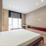 Chambre moderne avec lit, matelas, fenêtre et meuble bas