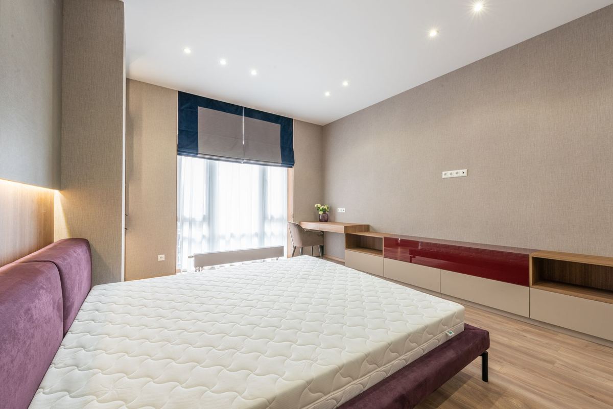 Chambre moderne avec lit, matelas, fenêtre et meuble bas