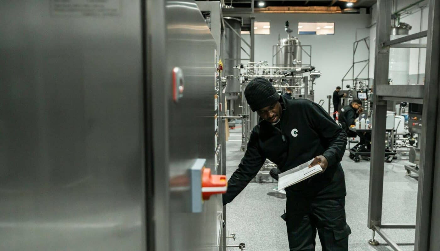 A man inspects equipment in a modern factory