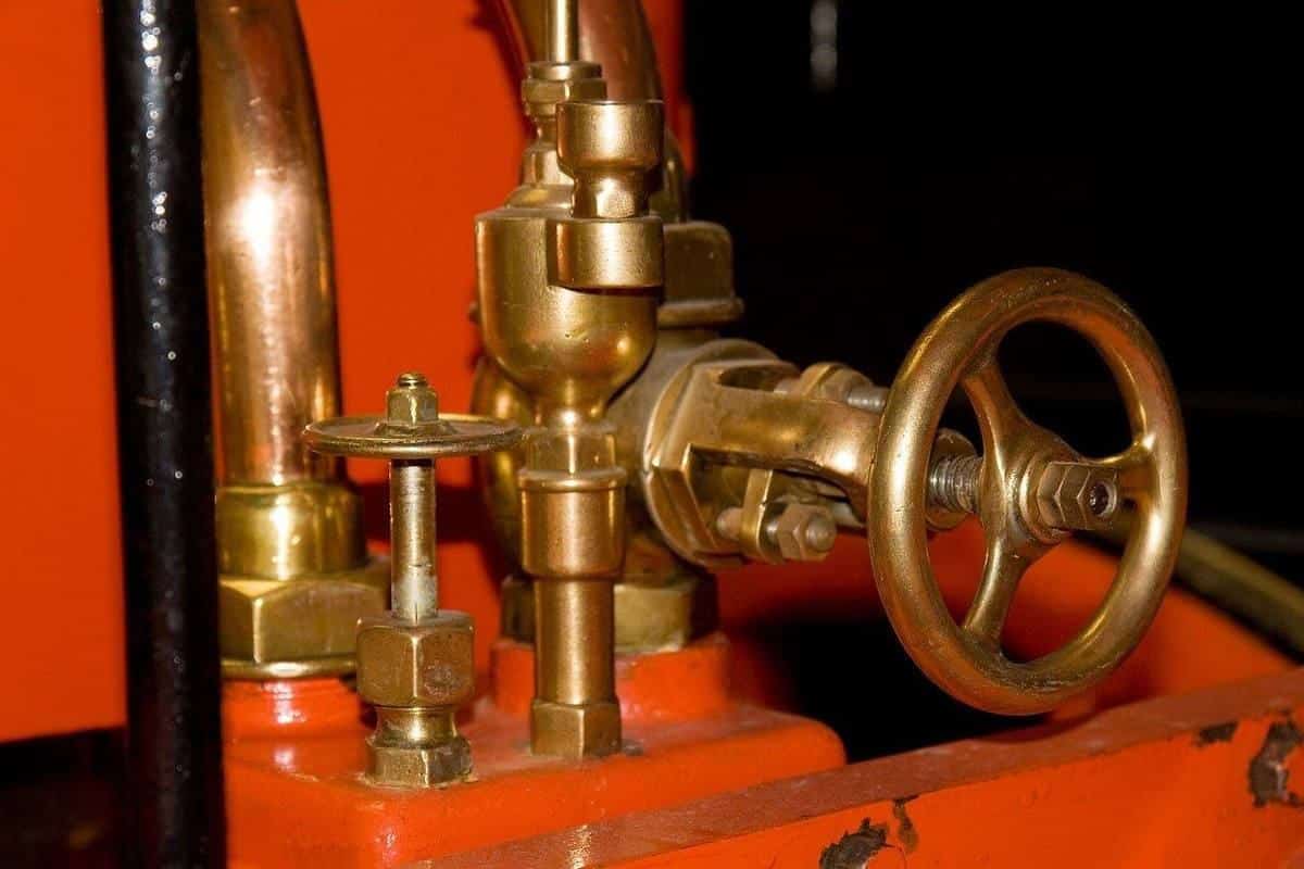 Mécanismes industriels en métal rouillé, roues et tuyaux sur fond orange