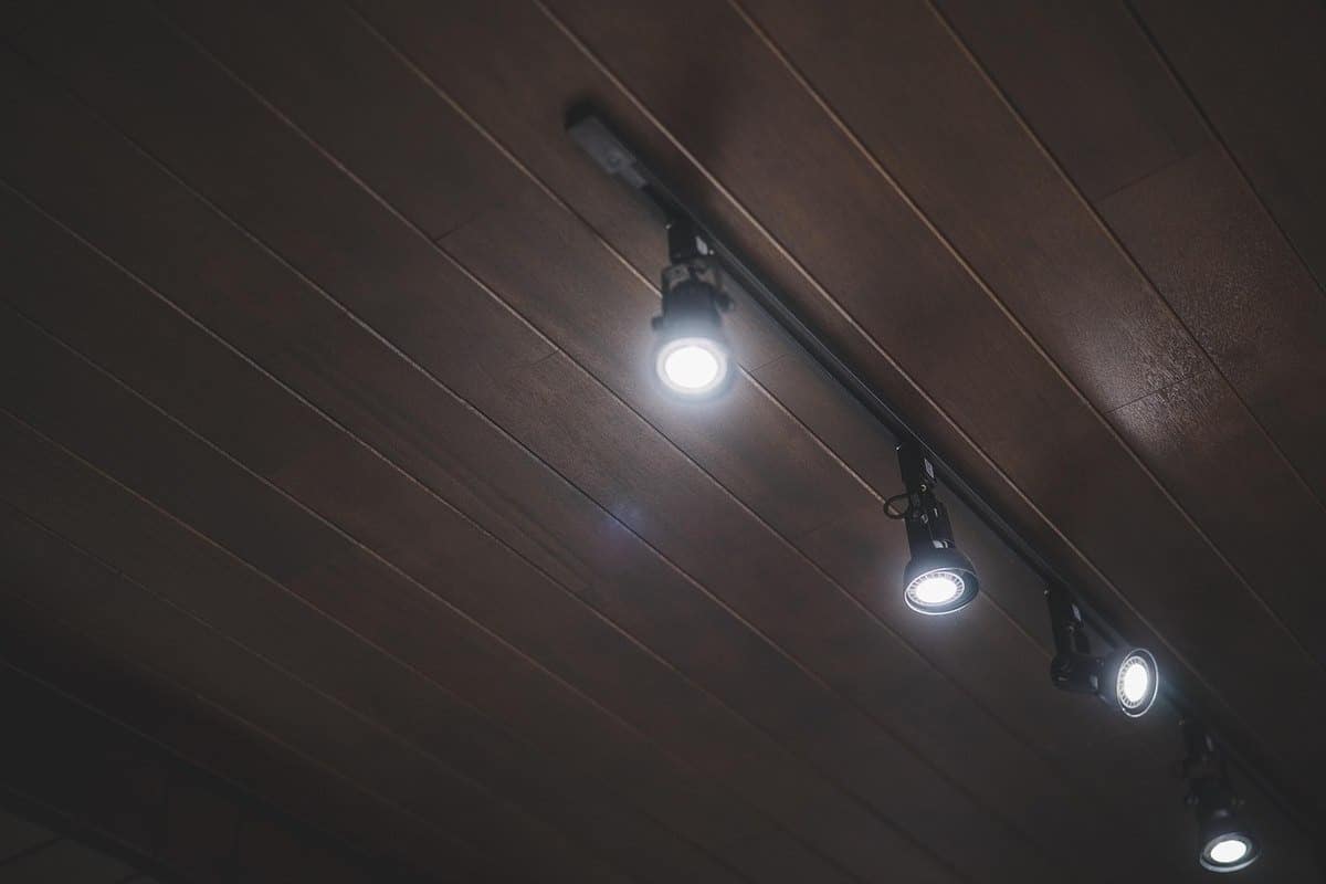 Quatre spots lumineux sur un plafond en bois